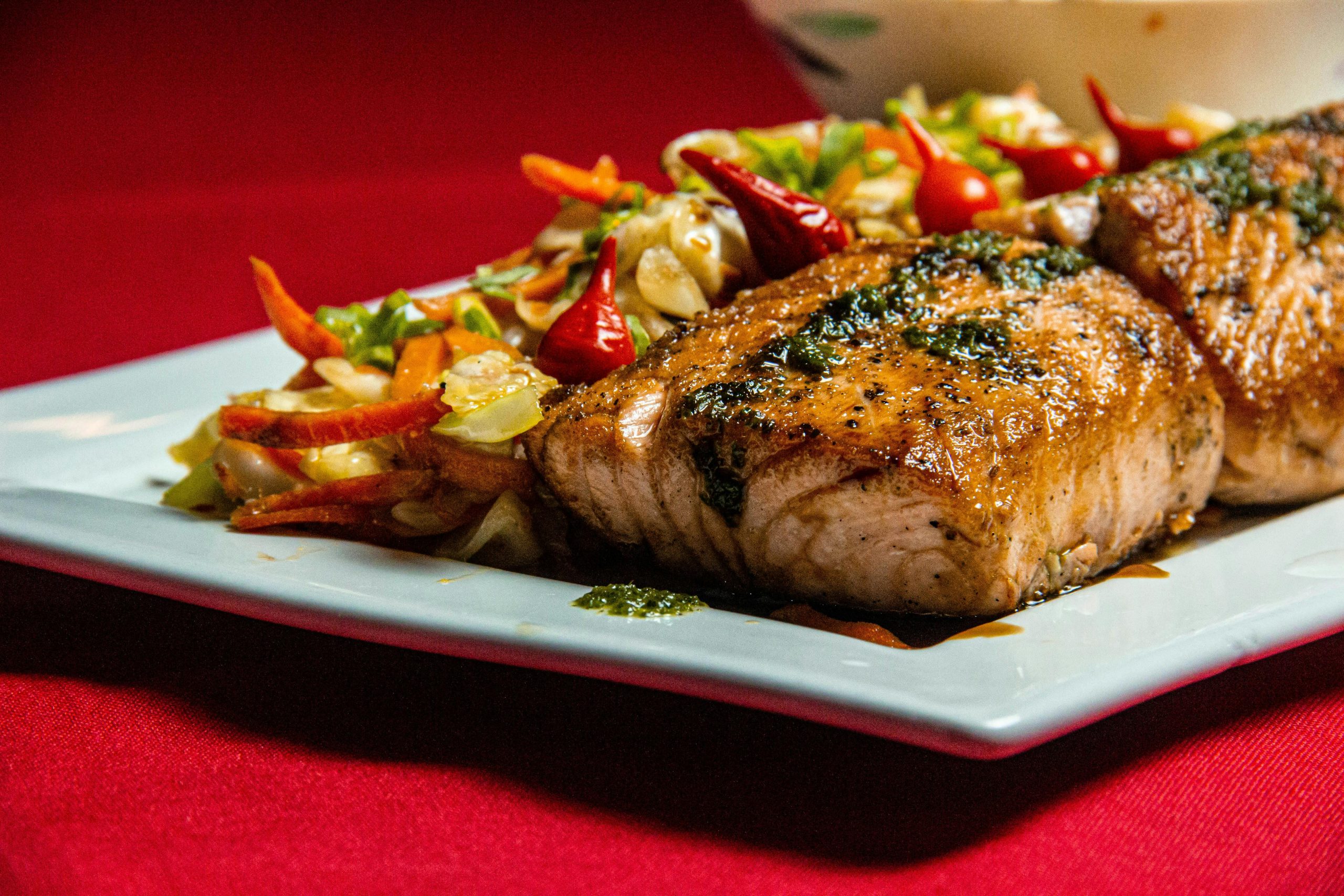 Delicious grilled salmon served with vibrant vegetables on a plate.